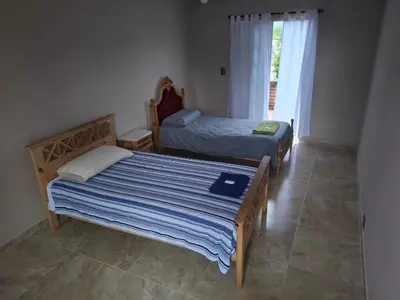 two beds in a room with a window at El sueño de papá in Santa María