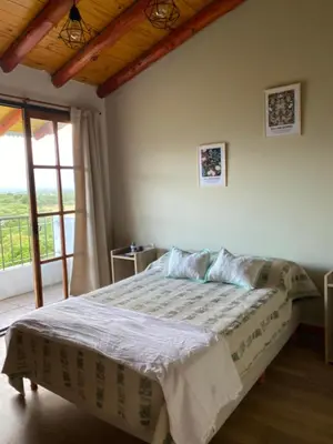 a bedroom with a bed in a room with a window at La Cuesta in Villa Cura Brochero