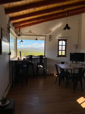 a dining room with a table and chairs and a window at La Cuesta in Villa Cura Brochero