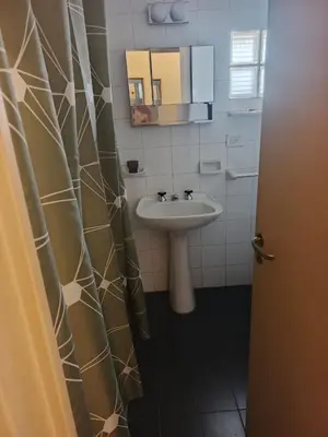a bathroom with a sink and a shower curtain at Departamento 2 dorm frente patio olmos in Cordoba