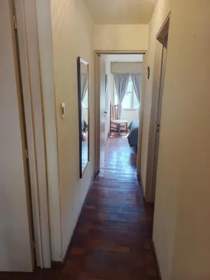 a hallway with a mirror on the wall and a room with a hallwayngthngth at Departamento 2 dorm frente patio olmos in Cordoba