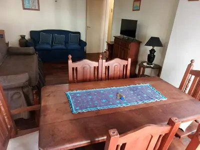 a living room with a wooden table and a couch at Departamento 2 dorm frente patio olmos in Cordoba