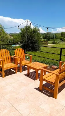two wooden benches and a picnic table on a patio at Departamento Valle de Luz in Alta Gracia