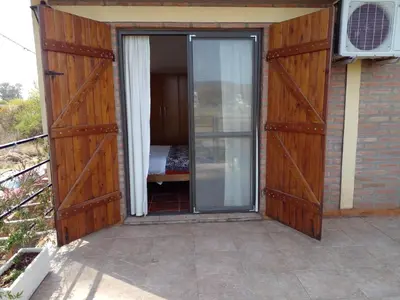 an open door to a room with a bed at Departamento Valle de Luz in Alta Gracia