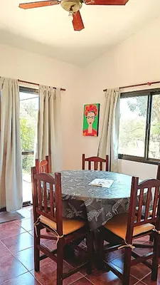 a dining room with a table with chairs and a ceiling fan at Departamento Valle de Luz in Alta Gracia