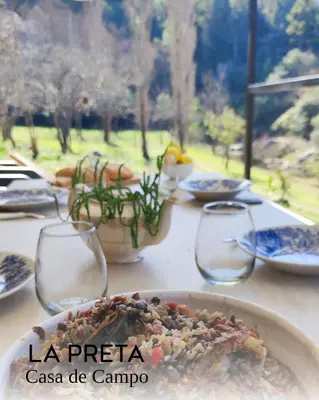 a table with a plate of food and wine glasses at La Preta, casa de campo in San Clemente
