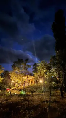 a building with lights in a field at night at La Preta, casa de campo in San Clemente