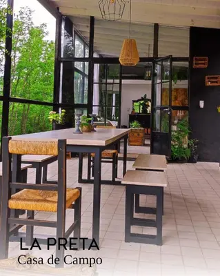 a patio with a table and benches in a building at La Preta, casa de campo in San Clemente