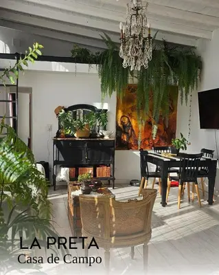 a living room with a dining table and a chandelier at La Preta, casa de campo in San Clemente