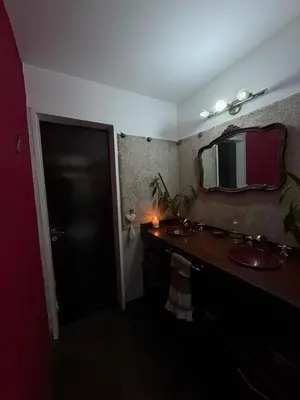 a bathroom with two sinks and a mirror on the wall at Departamento espacioso con gran patio para disfrutar MAYU SUMAJ in San Antonio de Arredondo