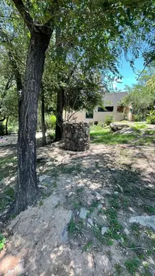 a tree and a stone structure under a tree at Departamento espacioso con gran patio para disfrutar MAYU SUMAJ in San Antonio de Arredondo