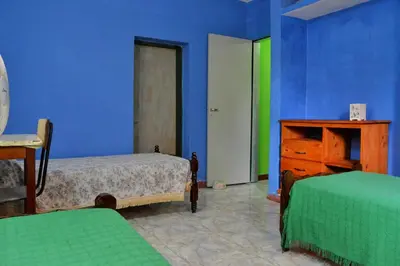 a bedroom with blue walls and two beds and a dresser at Departamento Parra in Panaholma