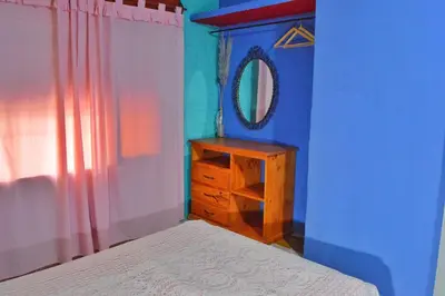 a bedroom with a bed and a dresser and a mirror at Departamento Parra in Panaholma