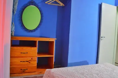 a bedroom with a blue wall with a mirror and a dresser at Departamento Parra in Panaholma