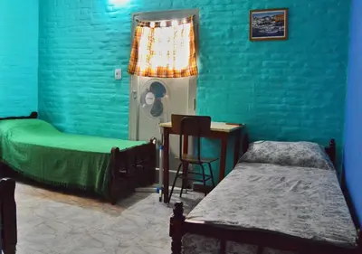 a bedroom with two beds and a green wall at Departamento Parra in Panaholma