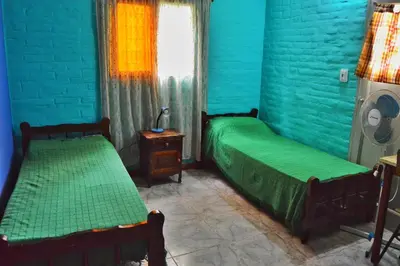 two beds in a room with blue walls and a window at Departamento Parra in Panaholma