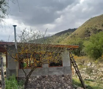 a stone house with a mountain in the background at Pie de Sierra in Los Hornillos