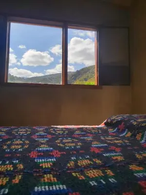 a bedroom with a bed and a window with a blanket at Pie de Sierra in Los Hornillos