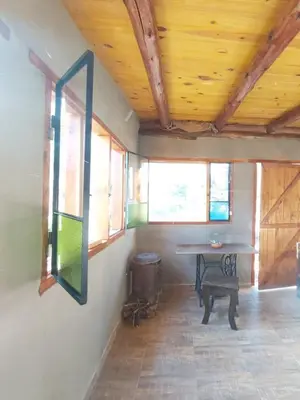 a room with a table and a bench and windows at Pie de Sierra in Los Hornillos