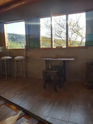 a table and chairs in a room with windows at Pie de Sierra in Los Hornillos
