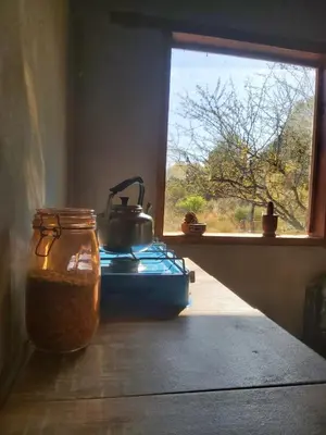 a tea pot sitting on top of a stove next to a window at Pie de Sierra in Los Hornillos