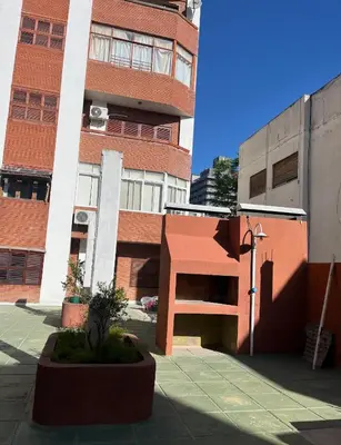 a tall brick building with a staircase in front of it at Dpto a pasos de la peatonal in Villa Carlos Paz