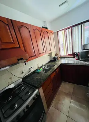 a kitchen with wooden cabinets and a stove top oven at Dpto a pasos de la peatonal in Villa Carlos Paz