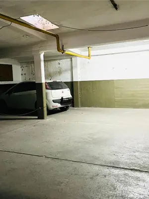 a parking garage with a white car parked in it at Dpto a pasos de la peatonal in Villa Carlos Paz