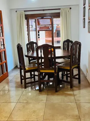 a wooden dining room table and chairs with a window at Dpto a pasos de la peatonal in Villa Carlos Paz