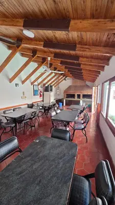 a room with tables and chairs and wooden ceilings at Dpto a pasos de la peatonal in Villa Carlos Paz