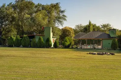 a house with a yard with sheep in front of it at Tierras de Breena in Los Reartes