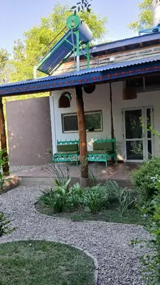 a house with green benches in front of it at Pacha es Arte in Villa Ciudad Parque
