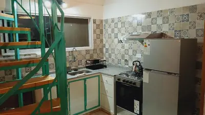 a small kitchen with a refrigerator and a stove at Pacha es Arte in Villa Ciudad Parque
