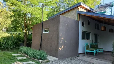 a house with a bench on the side of it at Pacha es Arte in Villa Ciudad Parque