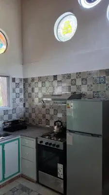 a kitchen with a stove and a refrigerator and a window at Pacha es Arte in Villa Ciudad Parque
