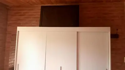a white cabinet with a television on top of it at Cabañas Las Pasionarias in Tanti