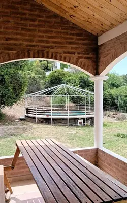 a wooden bench sitting on a porch with a table at Cabañas Las Pasionarias in Tanti