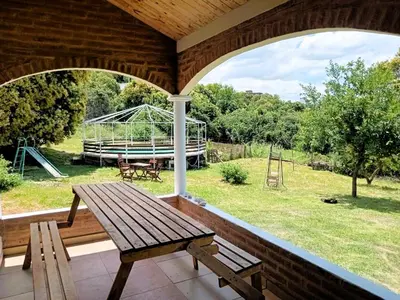 a porch with a wooden bench and a swing at Cabañas Las Pasionarias in Tanti