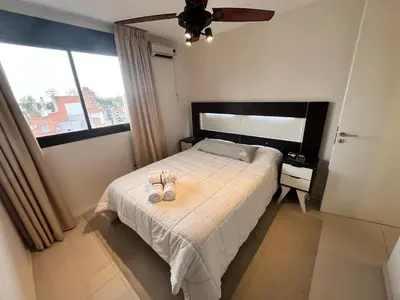 a bedroom with a bed with two shoes on it at Departamento 1 dormitorio con Piscina y Gran Vista en Nueva Cordoba in Cordoba