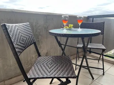 a table and two glasses of wine on a balcony at Departamento 1 dormitorio con Piscina y Gran Vista en Nueva Cordoba in Cordoba