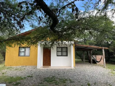 a small yellow and white house with a tree at cabañas Gerom in Pantanillo