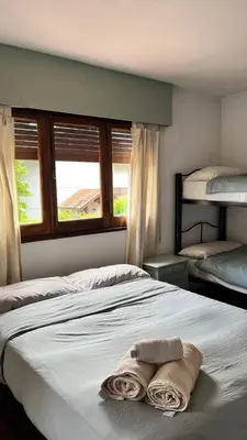 a bedroom with a bed with two towels on it at Hostel Cumbrecita Planeta in La Cumbrecita