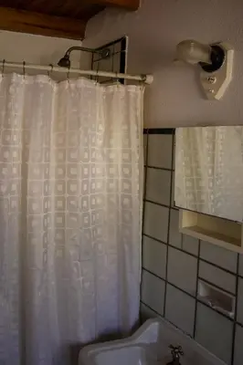 a bathroom with a white shower curtain and a sink at Hostel Cumbrecita Planeta in La Cumbrecita
