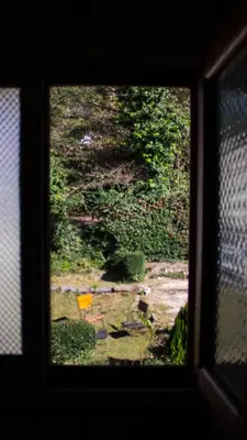 a view of a window with a view of a garden at Hostel Cumbrecita Planeta in La Cumbrecita