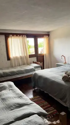 a bedroom with two beds and a window at Hostel Cumbrecita Planeta in La Cumbrecita