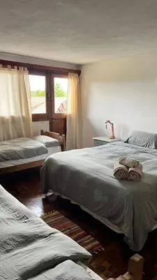 a bedroom with two beds and a window at Hostel Cumbrecita Planeta in La Cumbrecita