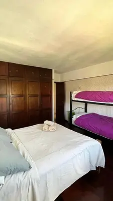 a bedroom with two beds and two bunk beds at Hostel Cumbrecita Planeta in La Cumbrecita