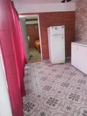 a kitchen with a white refrigerator and a tile floor at Depto Villa Soto in Mina Clavero