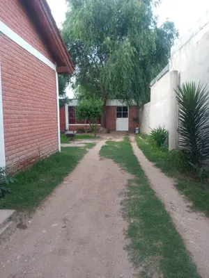 a dirt road next to a brick building at Depto Villa Soto in Mina Clavero