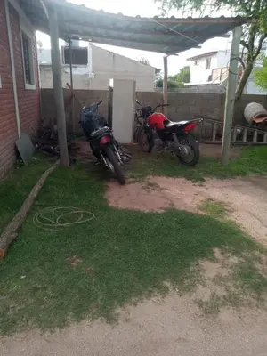 two motorcycles parked in a yard next to a house at Depto Villa Soto in Mina Clavero